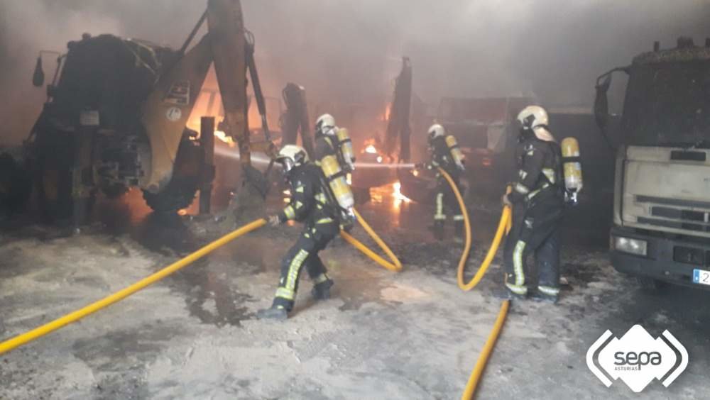Momento de las labores de extinción del incendio declarado en la nave municipal de Pola de Siero.