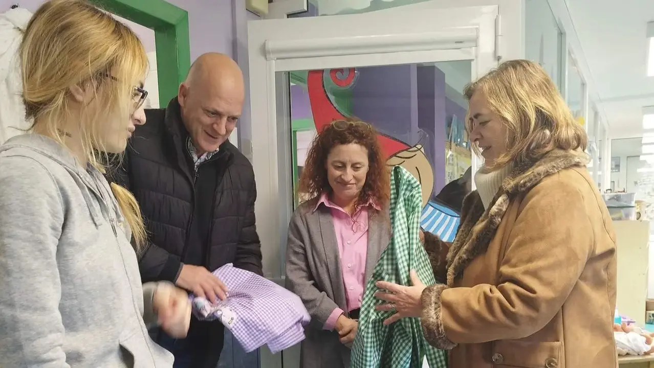 La concejala de educaci&oacute;n, Monste Alonso, entrega las nuevas batas a las educadoras de la Escuela Infantil, en presencia de la directora del centro y el monitor del taller de empleo.