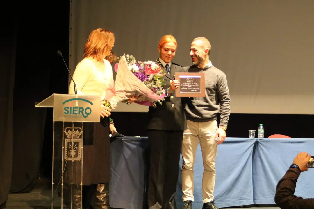 C&aacute;ndida Vicente , recibiendo de manos del alcalde la distinci&oacute;n como Mujer sierense del a&ntilde;o, en presencia de la concejala, Eva Iglesias