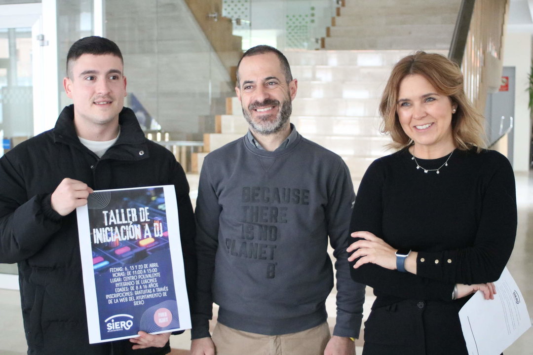 Pablo Águila muestra el cartel del taller acompañado por el alcalde y Eva Iglesias