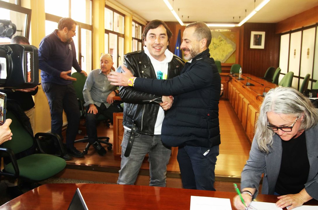 Gerardo Sanz y Ángel García se saludan tras la firma, con la teniente de alcalde de Llanera, Eva María Pérez, en primer término