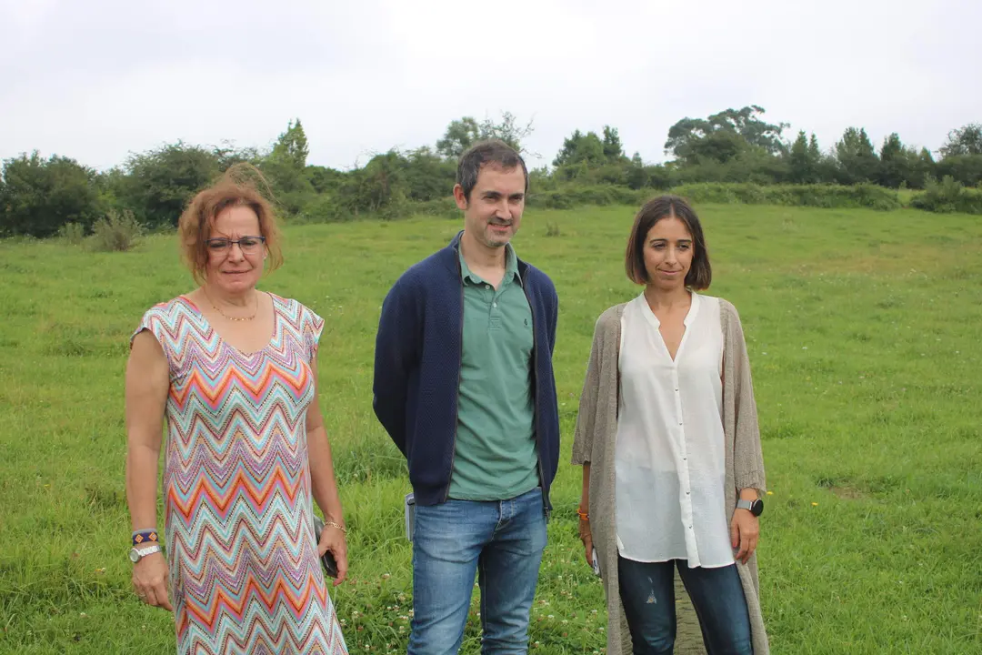 De izda a dcha, Mariv&iacute; Ugedo, Diego Ru&iacute;z-De la Pe&ntilde;a y Silvia T&aacute;rano, con los terrenos donde se pretende colocar un parque de bater&iacute;as, en Arg&uuml;elles, a sus espaldas