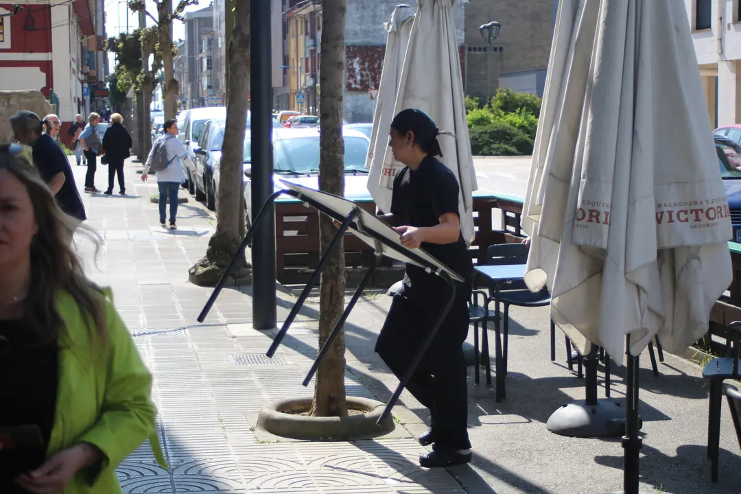 El personal de El Telagato, retirando las mesas de la terraza