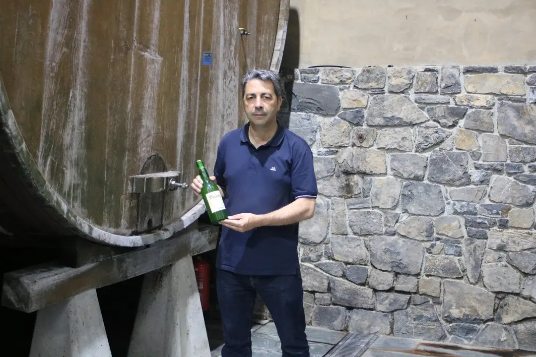 Cele Foncueva, en el llagar de Sariego, sujetando una de las botellas de la marca