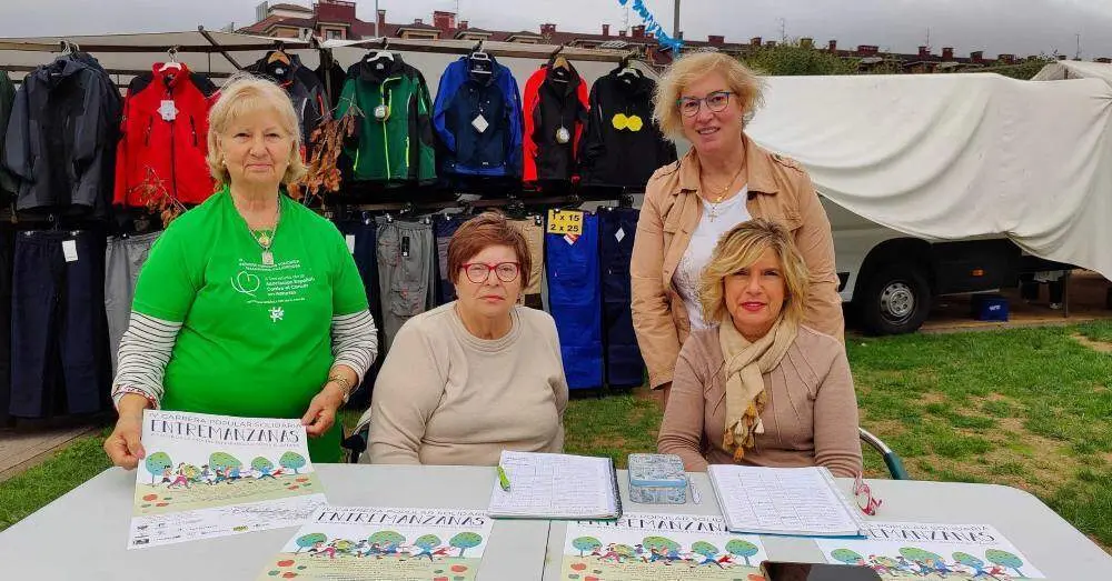 Voluntarias de la AECC de Villaviciosa haciendo inscripciones para la carrera popular del domingo.