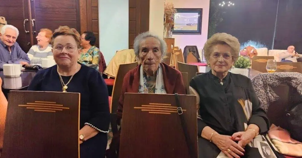 En el centro, Alicia, nombrada por el Ayuntamiento de Villaviciosa Abuela del A&ntilde;o 2025, junto a dos amigas.