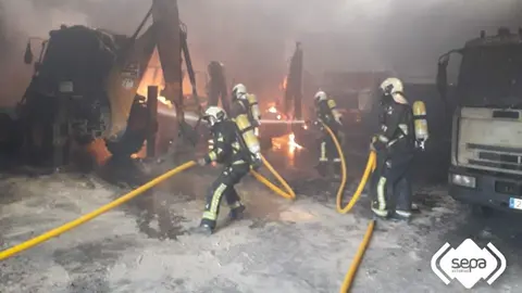 Momento de las labores de extinci&oacute;n del incendio declarado en la nave municipal de Pola de Siero.