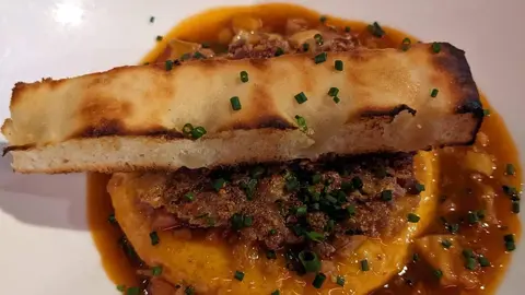 "Tortilla de patata y cebolla con salsa de callos y crujiente de oreja de cerdo" del Restaurante BRAVO di Premi&egrave;re