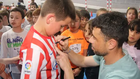 Javi Fuego firmando una camiseta del Real Sporting a un joven aficionado