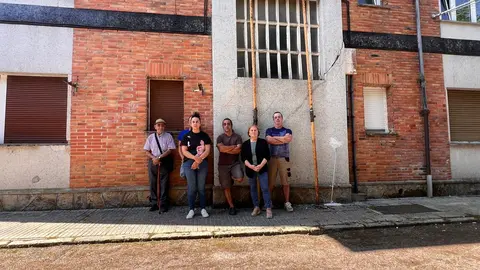 Vecinos de Pumarabule junto a una fachada apuntalada en uno de los bloques de viviendas afectados
