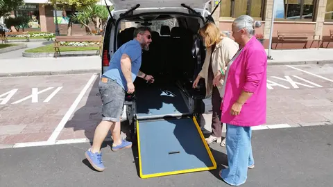 Santiago Rodr&iacute;guez, muestra el taxi adaptado que ya est&aacute; en servicio en Llanera, a la teniente alcalde, Eva Mar&iacute;a P&eacute;rez, primera por la derecha, y Montse Alonso, concejala de bienestar social, en la parada de taxis de Posada