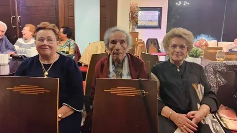En el centro, Alicia, nombrada por el Ayuntamiento de Villaviciosa Abuela del A&ntilde;o 2025, junto a dos amigas.