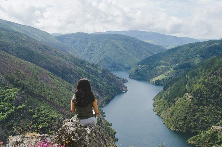 Woman observing the reservoir of Salime des Paicega, Asturias, Spain.