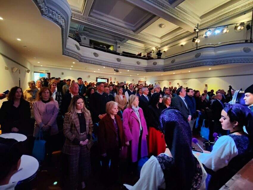Todos los asistentes de pie, cantando el himno de Asturias.
