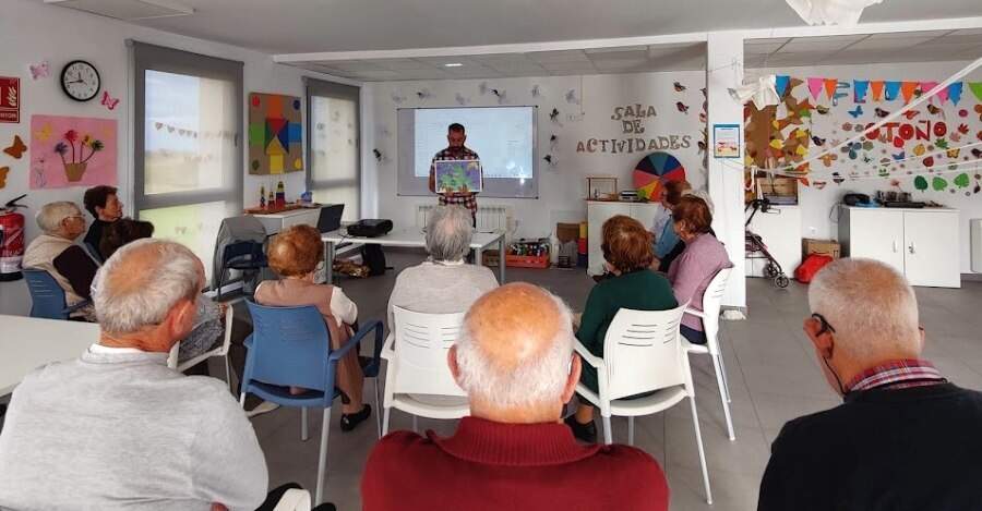 Fernando mostrandoles ilustraciones de Daniel García de otros cuentos con rutas.