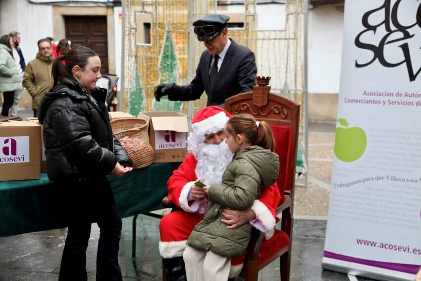 Papá Noel hablando con una de las niñas que esperaban para verle.