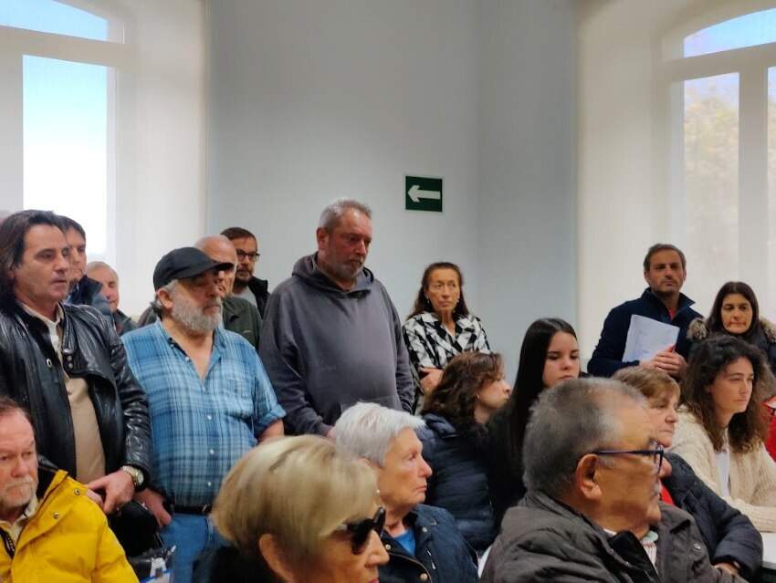 Vecinos asistentes a la reunión en las antiguas escuelas de Santa Mera.